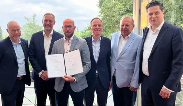 Sechs Vertreter der Geschäftsführung halten die langfristige Liefervereinbarung zwischen voestalpine und TSR Group